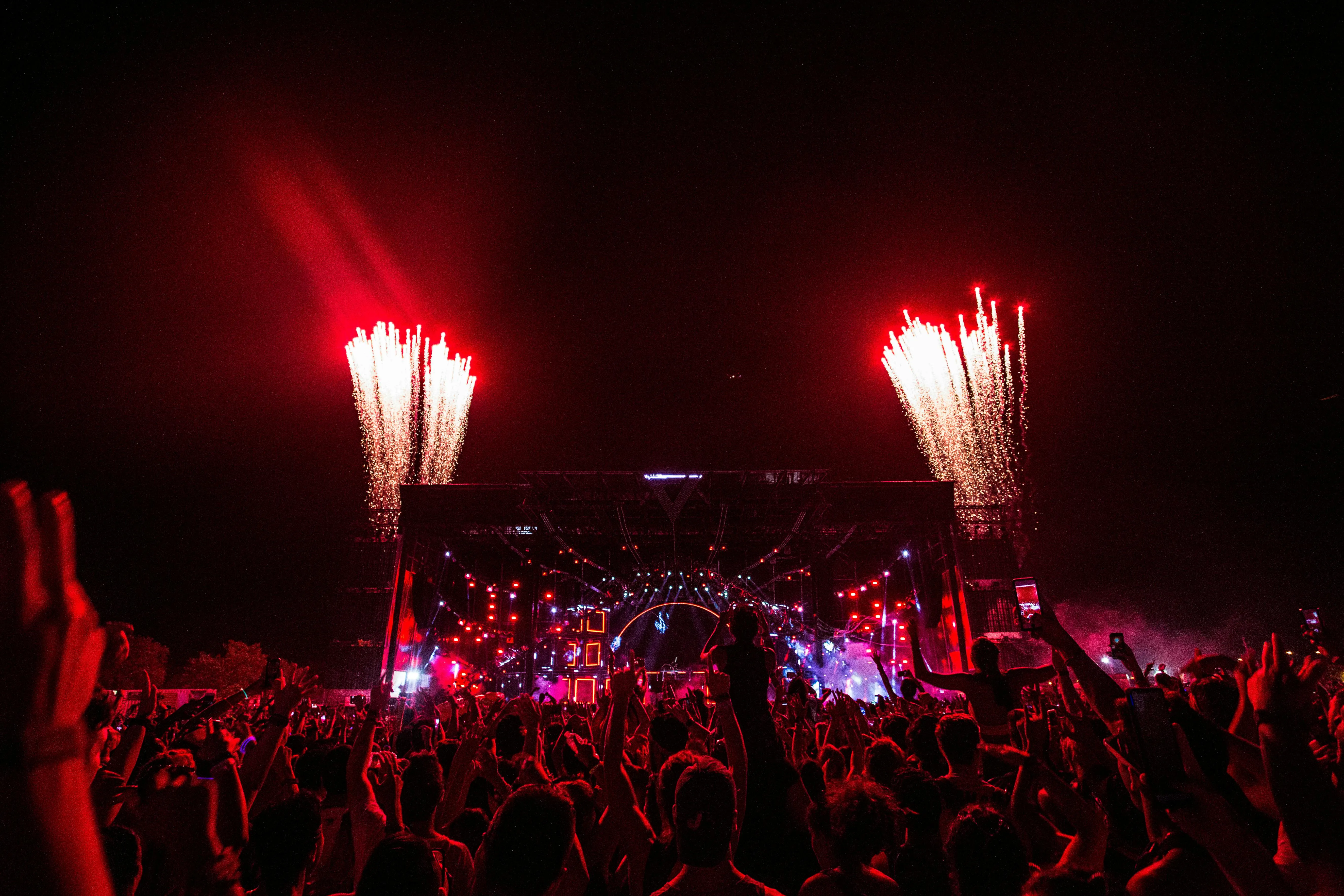 immersive festival stage with red fireworks and large goers